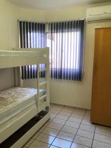 1 Schlafzimmer mit 2 Etagenbetten und einem Fenster in der Unterkunft Apto Frente Mar in Itapema
