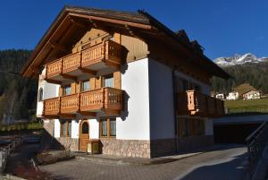 dom z drewnianymi balkonami po jego stronie w obiekcie Star Begn w mieście Soraga