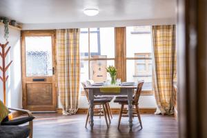 a dining room with a table and chairs and a window at The Old Dairy Mill Street in Crediton