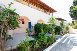 a courtyard of a house with plants and trees at Vanas Apartments in Spetses