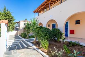 a villa with a palm tree in front of a building at Vanas Apartments in Spetses