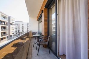 - Balcón con mesa y sillas en un edificio en Lovely Home at West Residence, en Oradea
