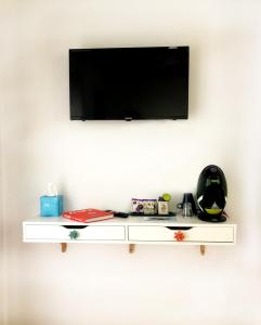 un estante blanco con un televisor en la pared en La Casa de La Menora en Onil
