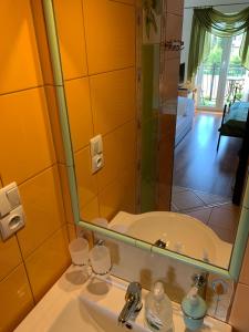 La salle de bains est pourvue d'un lavabo, d'un miroir et d'une baignoire. dans l'établissement Villa Remedios, à Łeba