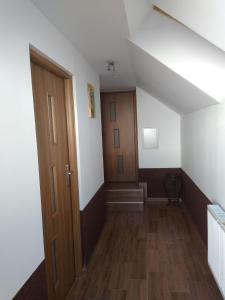 an attic hallway with a wooden door and stairs at U Beaty, niezależne mieszkania do wynajęcia in Ochotnica Górna