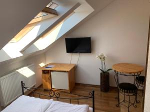 a room with a bed and a tv and a table at Villa Remedios in Łeba