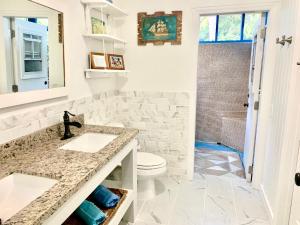 a bathroom with a sink and a toilet at Andros Beach Club in Kemps Bay