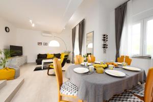 een woonkamer met een tafel en gele stoelen bij Kuća za odmor Diraki in Rijeka