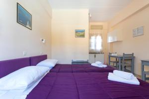 a bedroom with a purple bed with white pillows at Vanas Apartments in Spetses