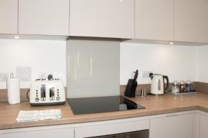 a kitchen counter with a toaster and appliances on it at TMS Beautiful 2 Bedroom Apartment!Ensuite!Dovestone Lakeside in West Thurrock