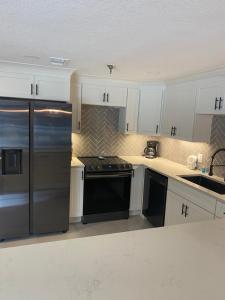 a kitchen with white cabinets and a stainless steel refrigerator at River Place Condos #111 3BD in Pigeon Forge