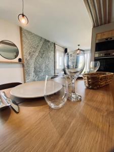 una mesa de madera con dos copas de vino. en Maison en pierres au calme près d'Ancenis, en Mésanger