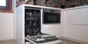 a kitchen with a dishwasher with a tv in it at I Fiori nel golfo di Baratti in Baratti