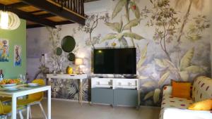 a living room with a flat screen tv on a wall at I Fiori nel golfo di Baratti in Baratti