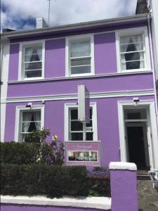 uma casa púrpura com um cartaz em frente em Newburgh Guesthouse em Torquay