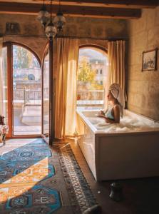 a woman sitting in a bath tub in a room at Angel Cave Suite in Göreme