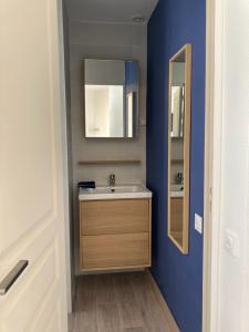 a bathroom with a sink and a mirror at La Capitane in La Baule