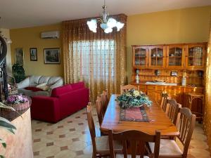 sala de estar con mesa y sofá rojo en Romano Holiday en Marina di Pescoluse