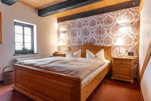 Schlafzimmer mit einem großen Bett mit einem Kopfteil aus Holz in der Unterkunft Weingut Schuh - Pension Zur Bosel in Coswig