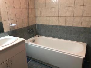 een badkamer met een wit bad naast een wastafel bij Flora Apartment 612A in Borovets