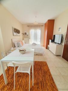 a bedroom with a bed and a white table and chair at Stergios_Apartments 06 in Kozani