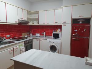 cocina con armarios blancos y nevera roja en Muxía Apartamento Malecón enfrente al puerto 4 personas en Muxía