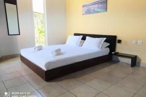 una camera da letto con un grande letto con lenzuola e cuscini bianchi di Raisin House a Koukounariá