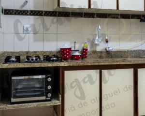 blat kuchenny z kuchenką mikrofalową i zlewem w obiekcie 03 Dormitorios em Frente a Praia do Itararé / S.V w mieście São Vicente