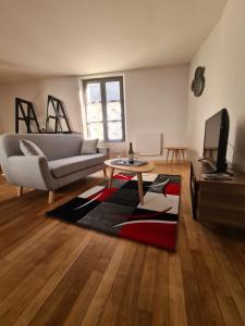 sala de estar con sofá y mesa en Les Logis du rempart, en Loches