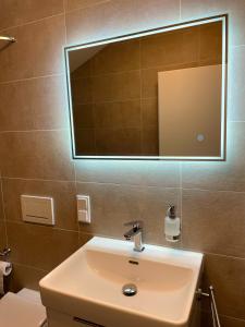 a bathroom with a sink and a mirror at Gästehaus Veenstra in Kelberg