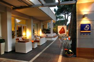 a patio with couches and chairs on a building at Hotel Eros Residence in Cervia