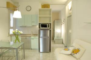 a kitchen with a stainless steel refrigerator and a table at Hotel Eros Residence in Cervia