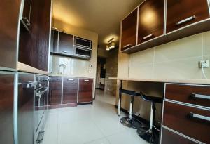 a kitchen with wooden cabinets and a counter top at Apartamenty Lubin - Cuprum in Lubin