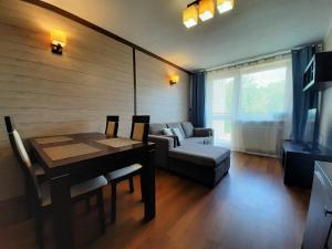 een woonkamer met een tafel en een bank bij Apartamenty Lubin - Cuprum in Lubin