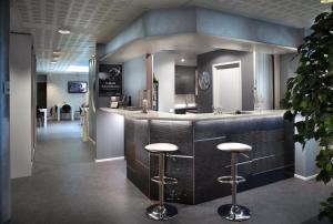 a lobby with a bar with stools in a room at Hotel CityHovi in Rauma