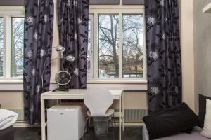 a room with a desk and two windows at Hotel CityHovi in Rauma