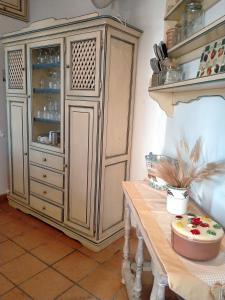 a large wooden cabinet in a kitchen with a table at Villa Rossi in Polignano a Mare