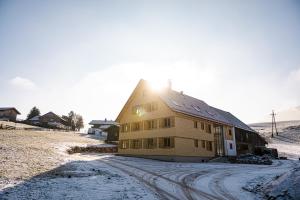 Una casa en la nieve con el sol detrás. en Nattrars Huimat, en Obermaiselstein
