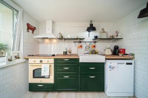 cocina con armarios verdes y nevera blanca en Casa de la Mare - Albena en Albena