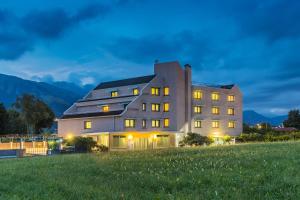 a house on top of a hill at night at Aviano Palace Hotel in Aviano