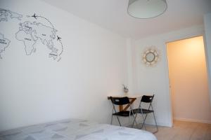 サン・セバスティアン・シュル・ロワールにあるAu clos du bonheurのベッドルーム1室(椅子2脚、壁に世界地図付)