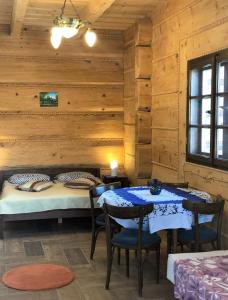 a bedroom with a bed and a table and chairs at Chochlik in Ustrzyki Dolne