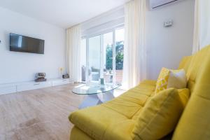 - un salon avec un canapé jaune et une table en verre dans l'établissement Apartment Maria Vir, à Vir