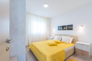 - une chambre avec un lit jaune et une couverture jaune dans l'établissement Apartment Maria Vir, à Vir