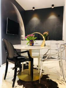 Un comedor con una mesa y sillas blancas. en Piper Dworzec & Targi, en Poznan