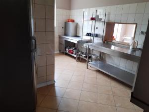 a kitchen with stainless steel appliances and a tiled floor at Agroturystyka Osieki in Osieki