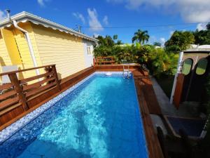 a swimming pool in front of a house at LES MULTIPLIANTS in Le Moule