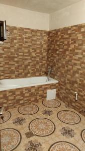 La salle de bains est pourvue d'une baignoire et de carrelage. dans l'établissement Dalila, à Corbu
