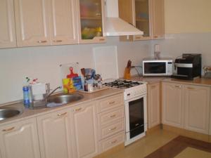 a kitchen with white cabinets and a stove top oven at Lime Guest House in Adler