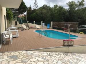 einen Pool mit Stühlen, einem Tisch und einer Terrasse in der Unterkunft Casa da Cavada in Caminha